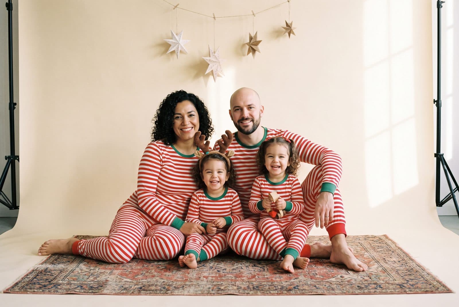 Une famille en pyjamas rayés de Noël assise sur un tapis